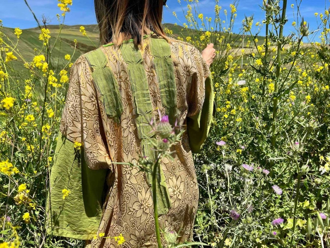 girl wearing an upcycled robe walking throuhg a field