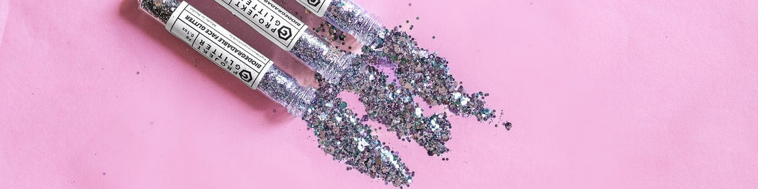 3 opened tubes of glitter against a pink background