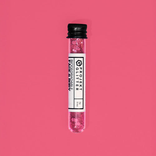 Test tube with pink glitter labeled 'Projekt Glitter' on a red background