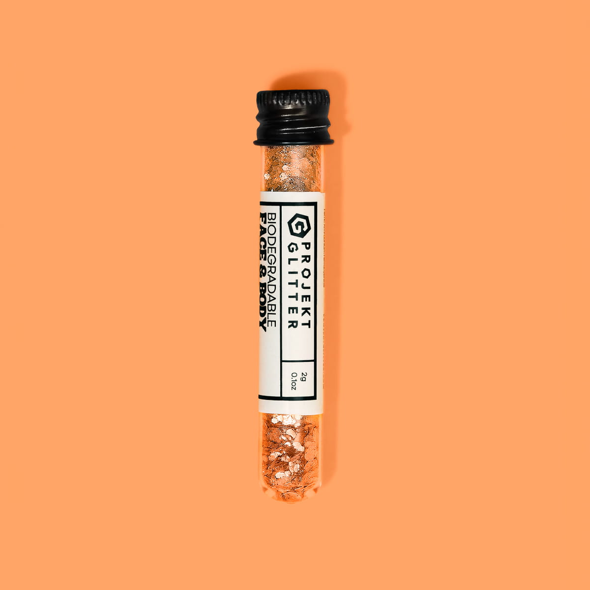 Small glass vial with glitter on an orange background