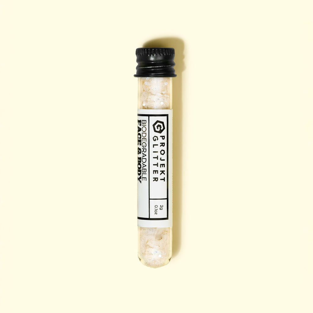 Test tube with glitter labeled 'Projekt Glitter' on a beige background