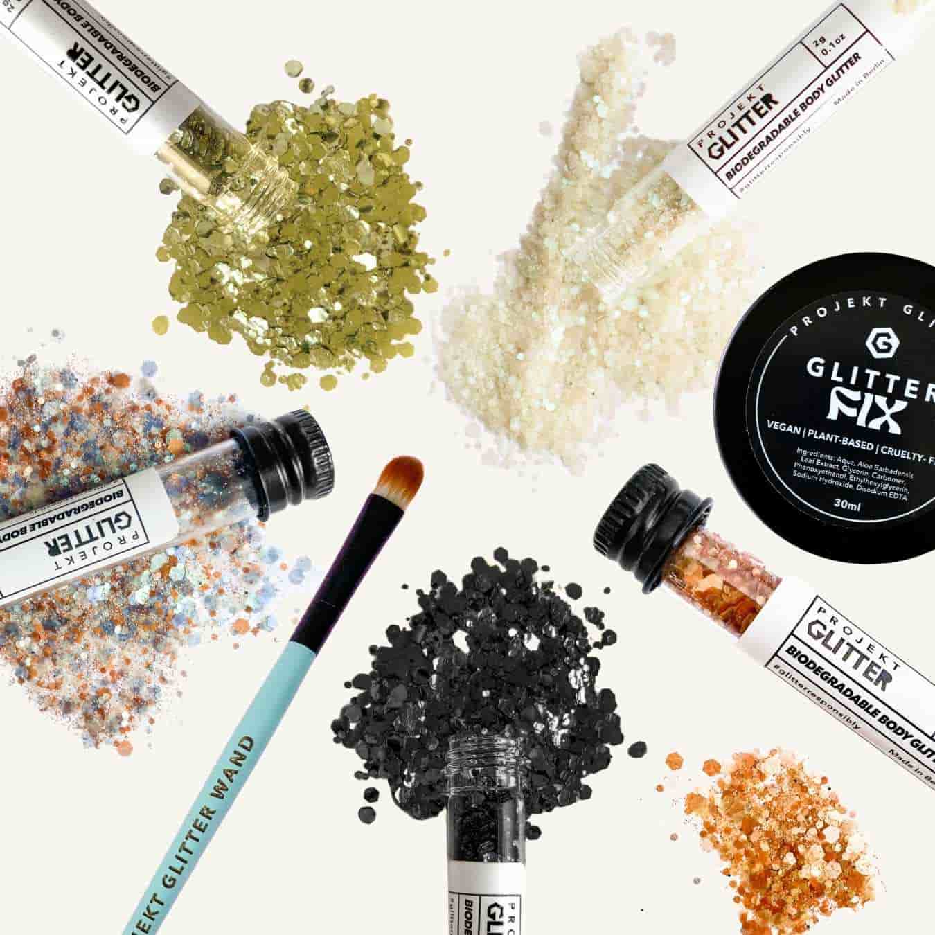 Collection of glitter products including bottles, jars, and a brush on a white background.